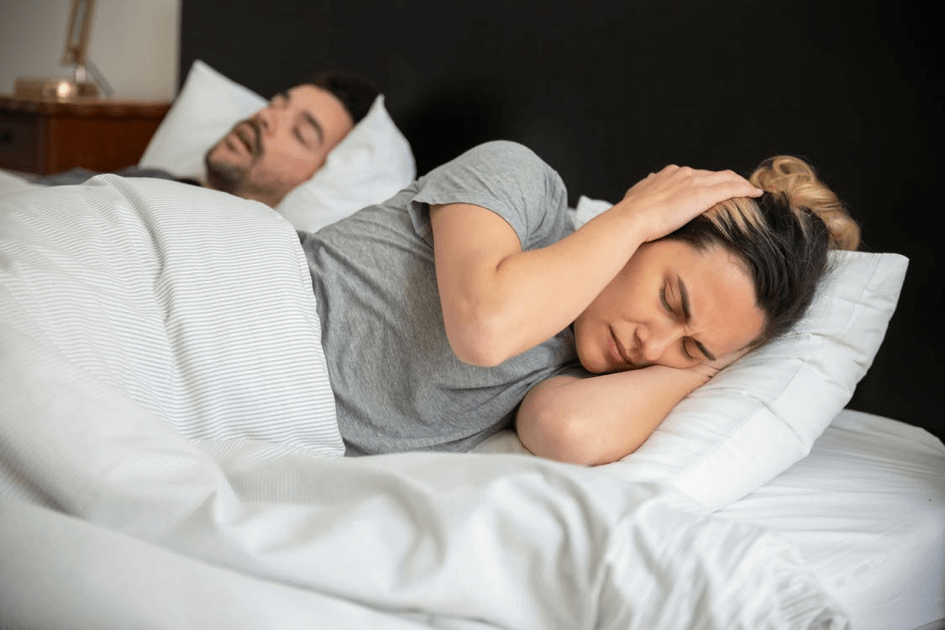 Couple dans un lit qui essaye de dormir